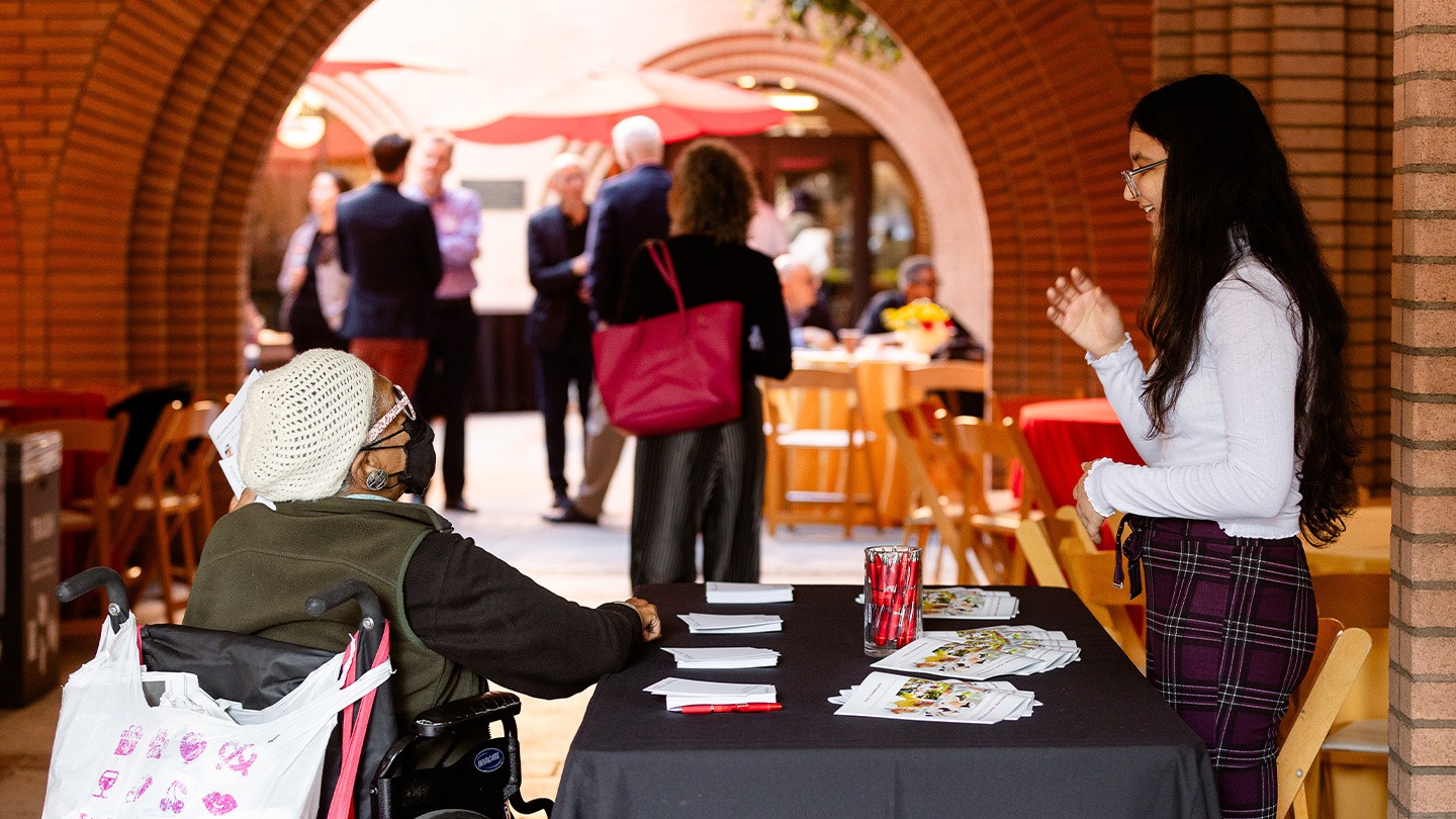 Color photograph of a person in a wheelchair checking into the Aging is Now / Aging is the Future: Entrepreneurship Symposium.