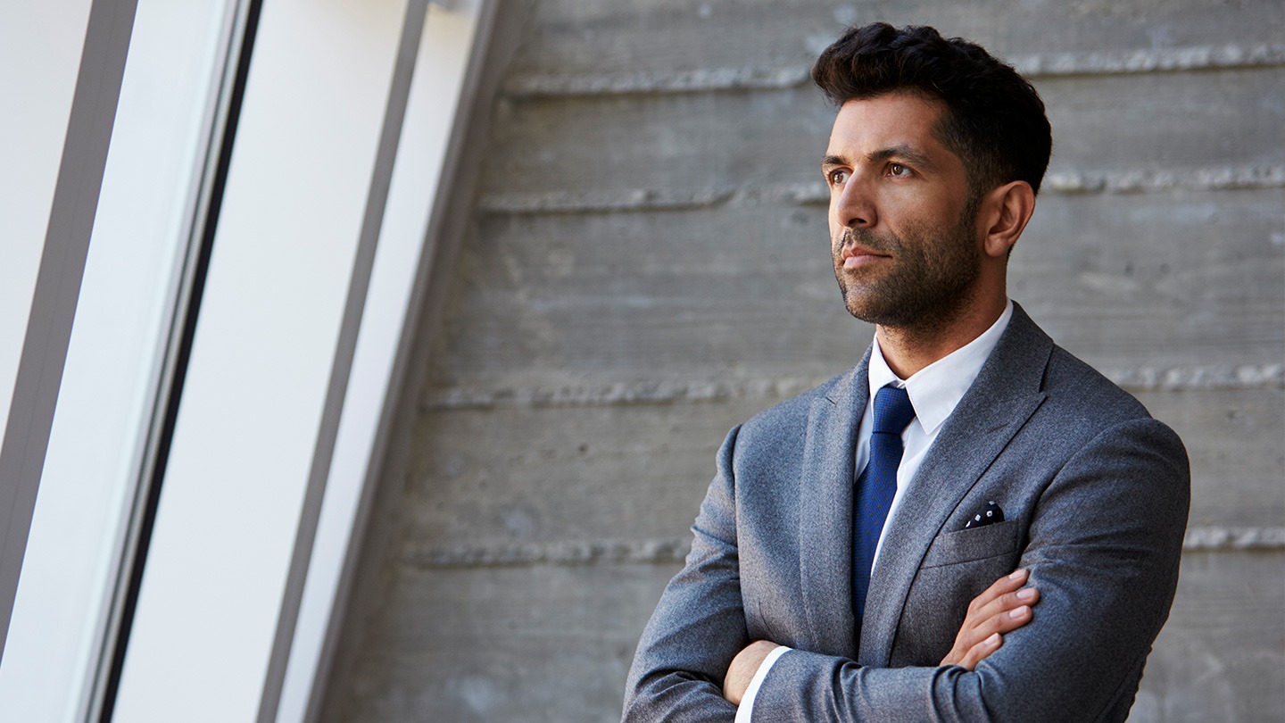 Male executive staring thoughtfully to the side.