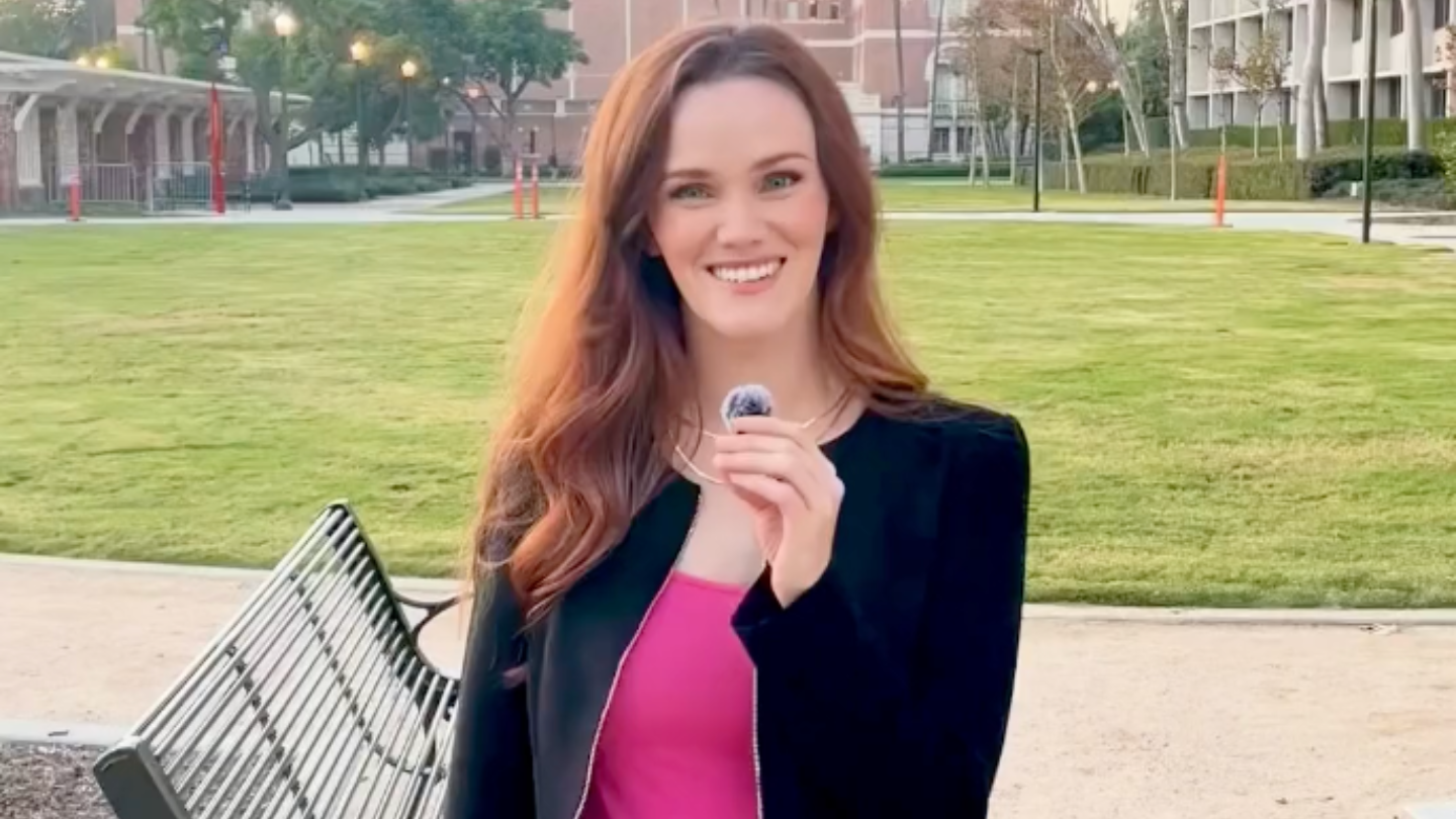 woman holding mic outside on campus