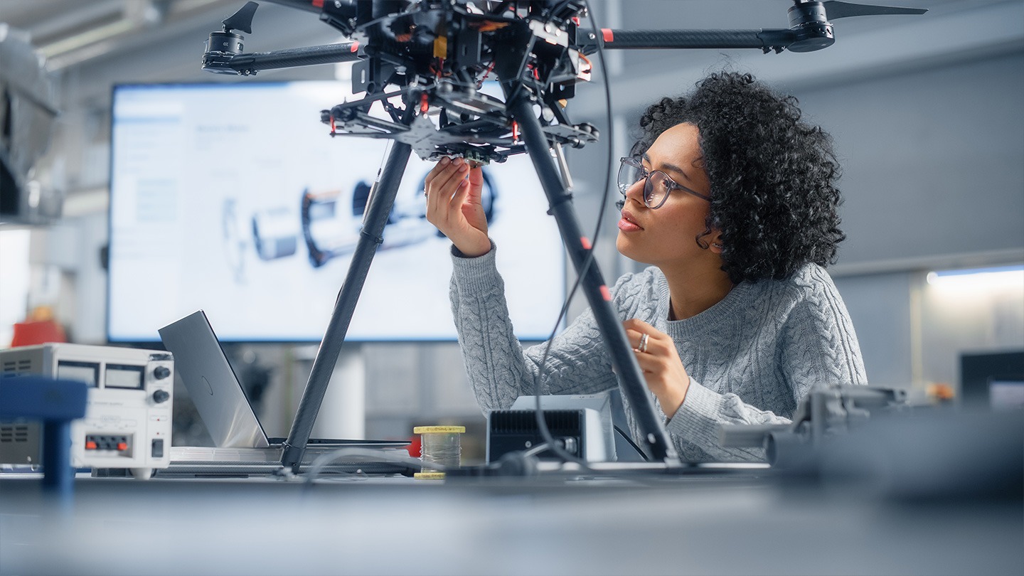 Color photograph of a person working on a device in a computer science lab.