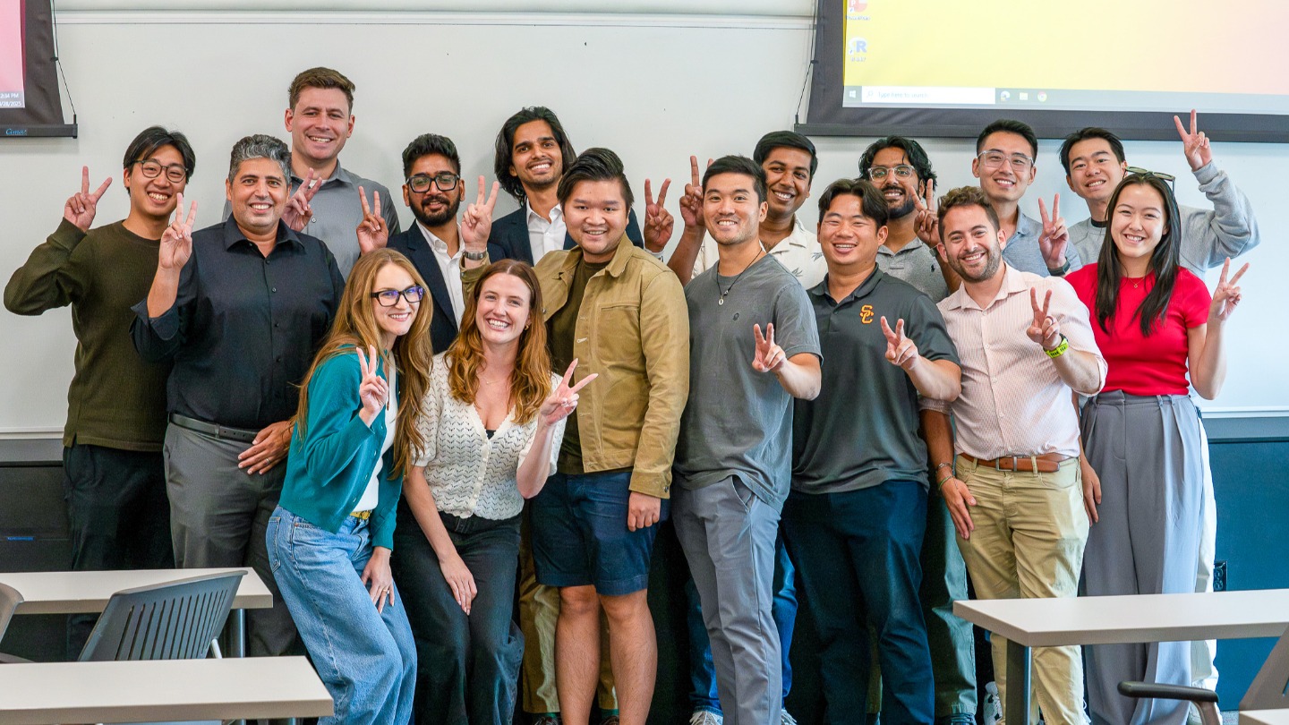FTMBA students and Ahmed Elshinnawy giving the Fight On sign