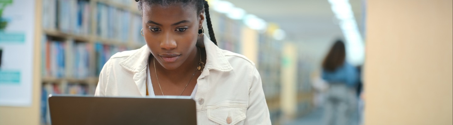 Girl in a libarary using laptop