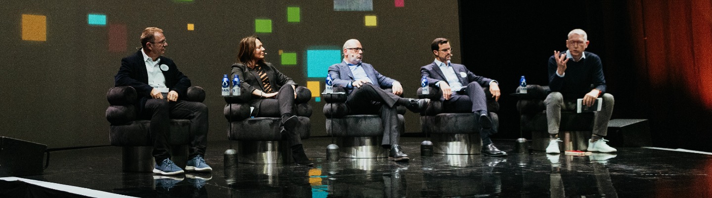 Panelists on stage in dark room