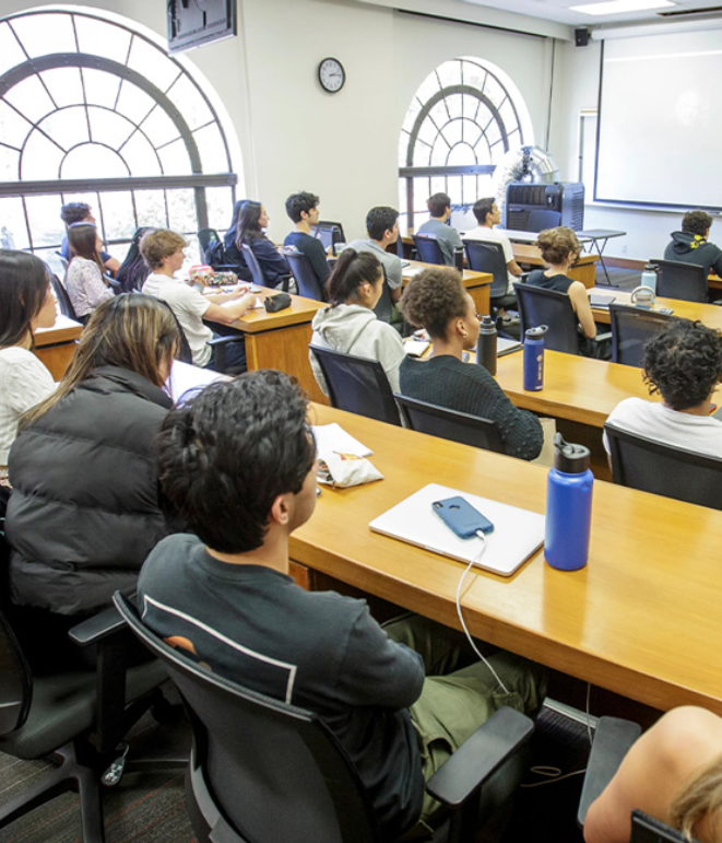 Students in a classroom listen to a lecture.