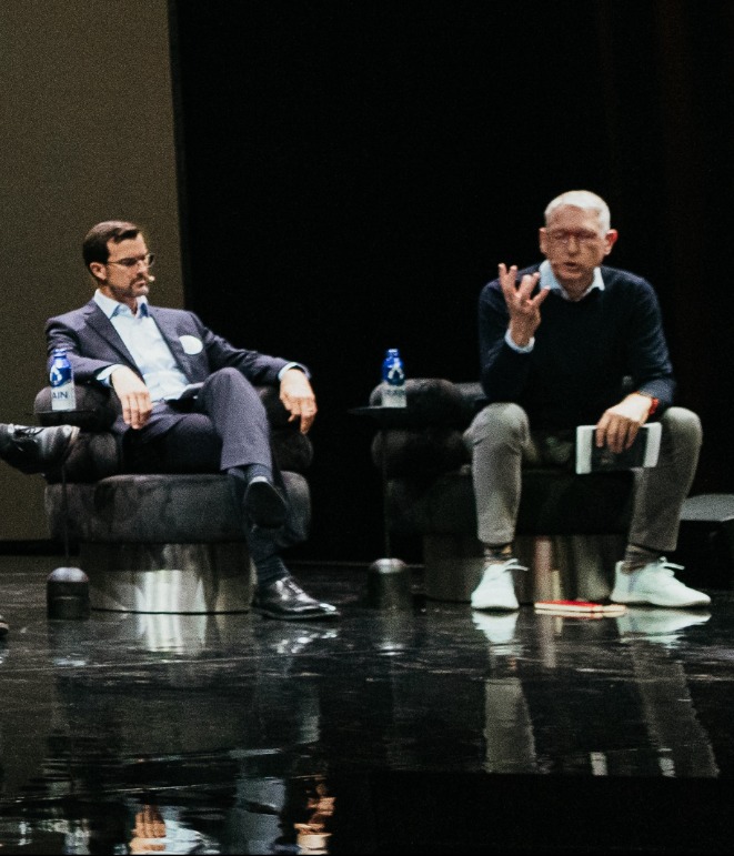 Panelists on stage in dark room