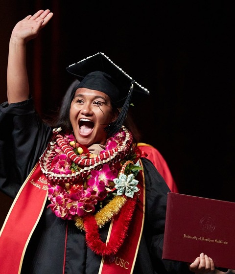 Color photograph of a USC Marshall student celebrating their graduation.