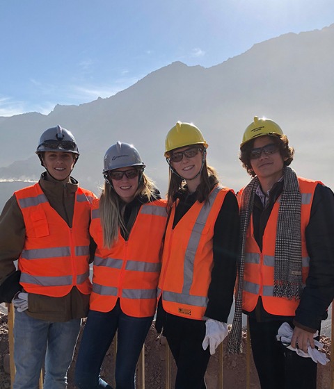 Four USC students visiting a construction site in Santiago, Chile on a sunny day.