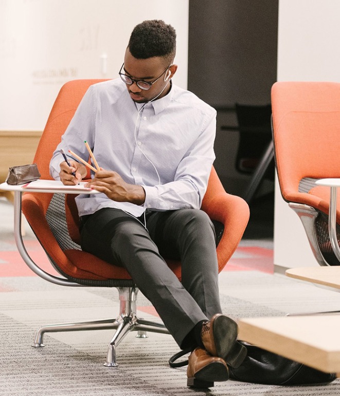 A male-presenting USC student taking notes.