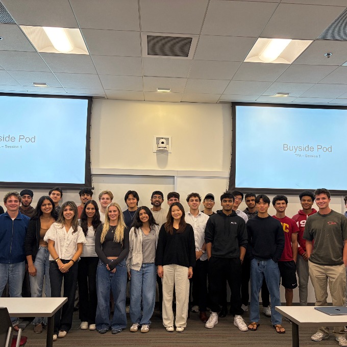A large group of students standing in a classroom taking a picture