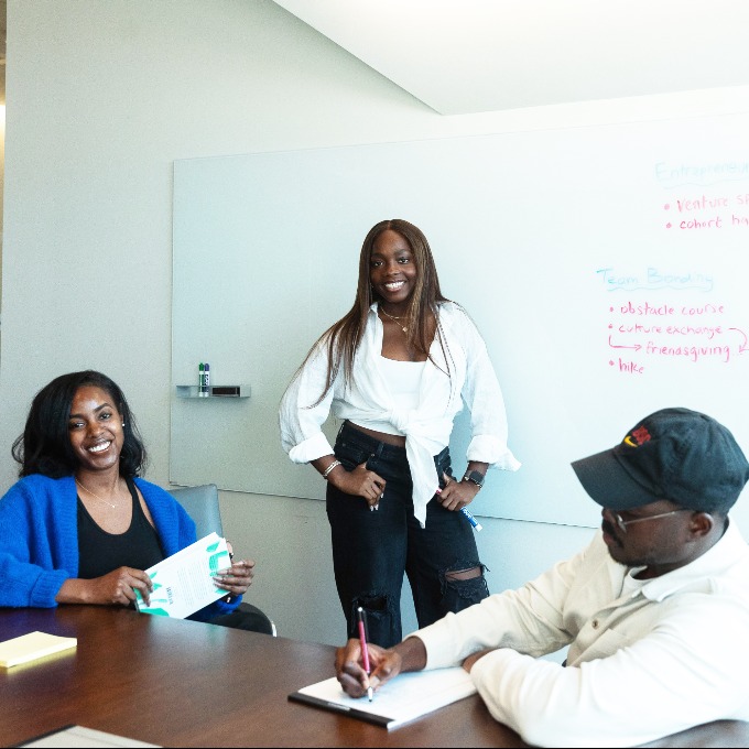 Three students in front of white board