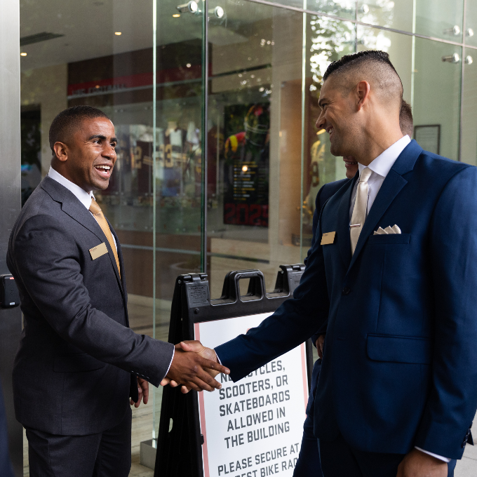 Two students shaking hands at an event.