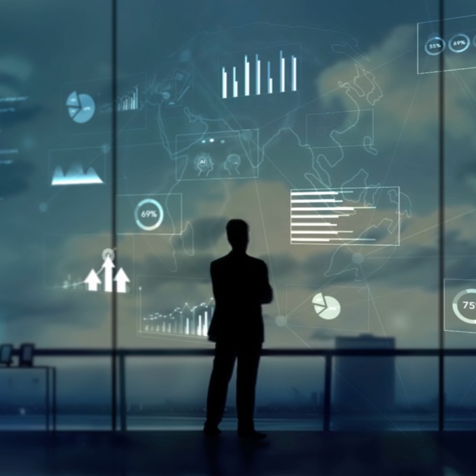 decorative image of businessman staring at graphs by a window