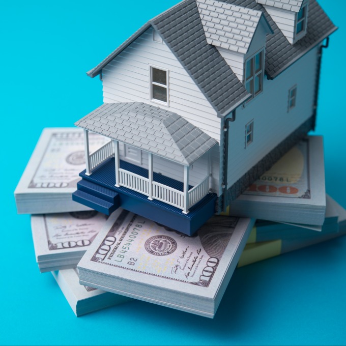 decorative image of a house on stacks of cash