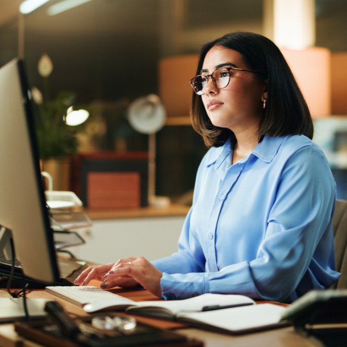 Woman wearing glasses working on her desktop computer