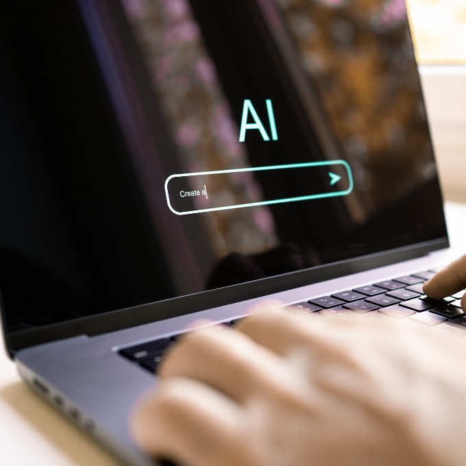 hands typing into AI on a computer