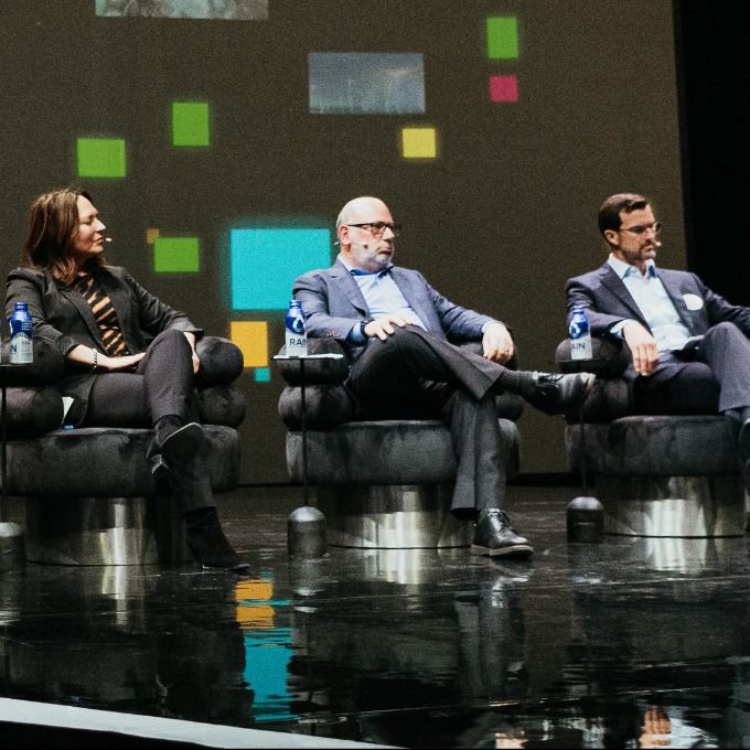 Panelists on stage in dark room
