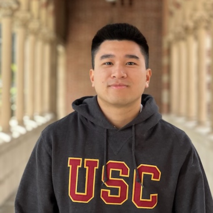 Brandon Tran, wearing a USC sweatshirt, smiling for the camera.