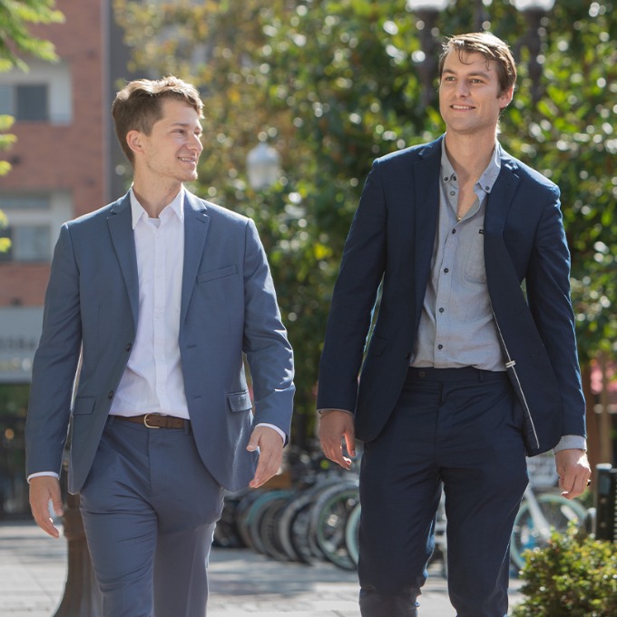 Color photograph of two male students walking on the campus of USC.