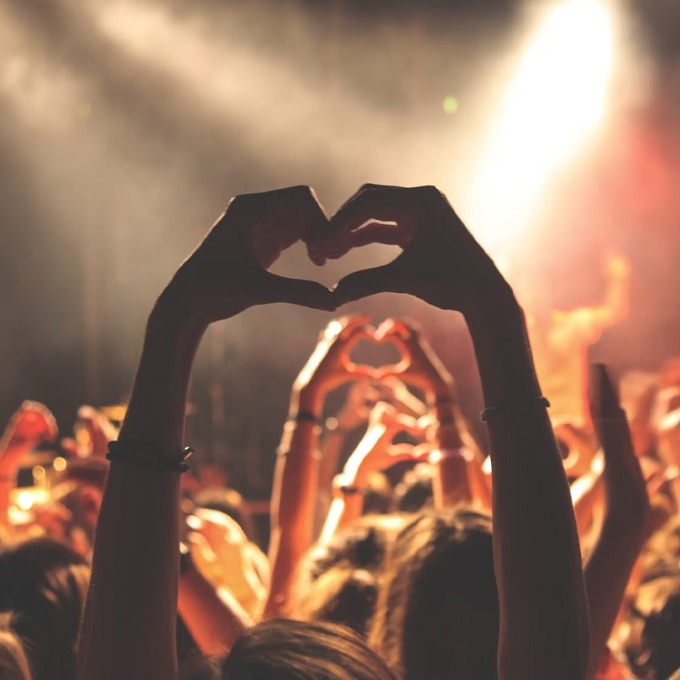 hands making a heart at a concert