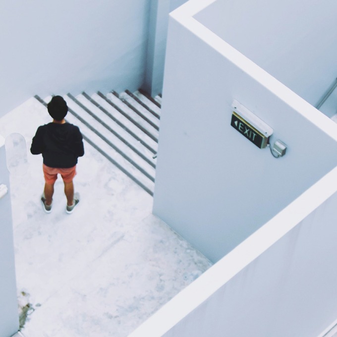 Aerial color photograph of a person standing at the top of a staircase next to a sign reading "Exit".