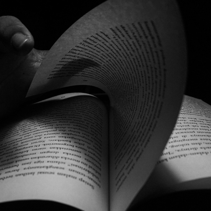 A hand turning the page of a book.