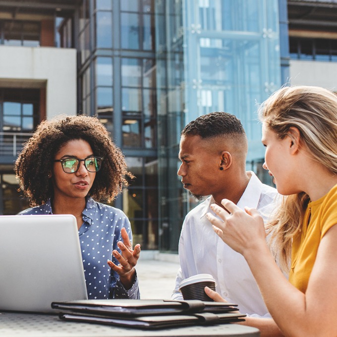 Four business professionals at an outdoor workshop.