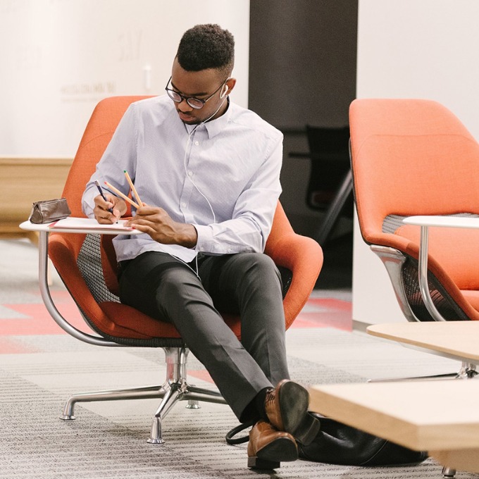 A male-presenting USC student taking notes.