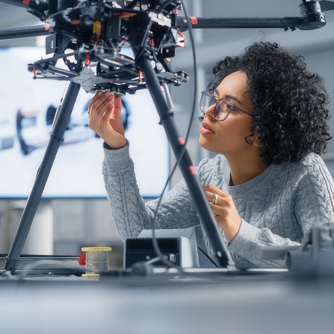 Color photograph of a person working on a device in a computer science lab.