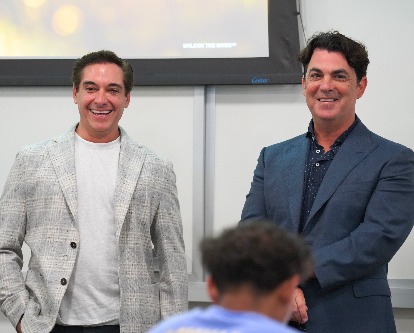 Chad Tons and Miles Rogers smiling in front of the class