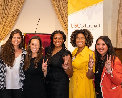 Group of event participants showing Fight On sign