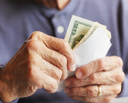 Aging individual holding money and a bill of sale.