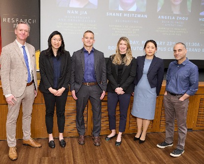 Five faculty members pose for a photo at the Research Fair