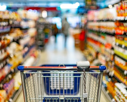 Shopping cart centered in a grocery store aisle.