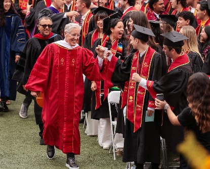 Pete Carroll walking down the aisle at Commencement