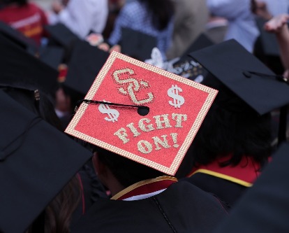 A graduate's mortarboard decorated in red with SC and Fight On!