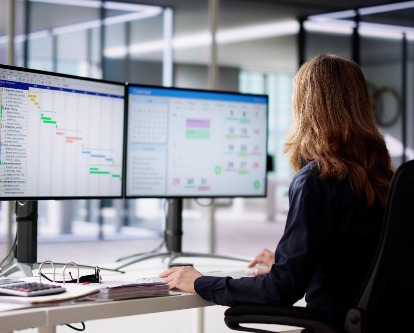 an employee sitting at two computer monitors