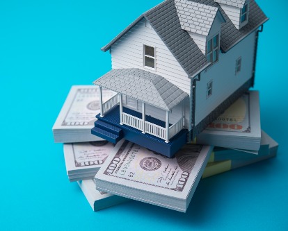 decorative image of a house on stacks of cash