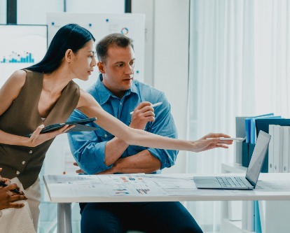 Three colleagues reviewing something on a computer screen