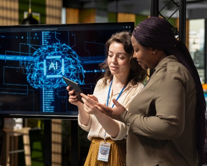 two employees working with AI on a tablet