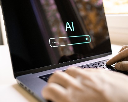hands typing into AI on a computer