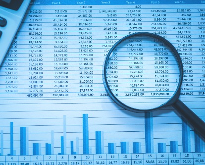 decorative image of magnifying glass on a spreadsheet
