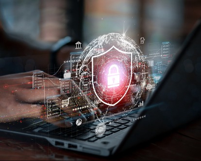 Hands on a laptop with a graphic overlay of a cyber halogram