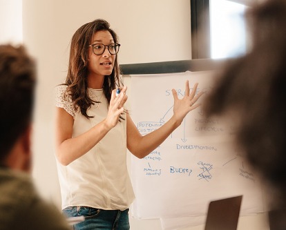 Businesswoman explaining new plan to colleagues in conference room. Businesspeople during meeting in office board room.