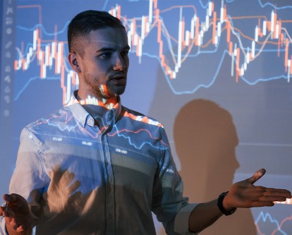 Man is standing near projector and showing graphs and business graphs.