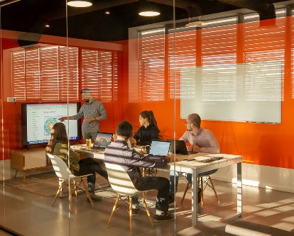 Looking in on a creative, techy conference room during a presentation.