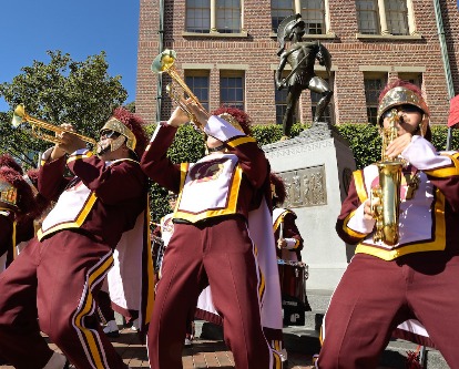 Color photo of horn players from USC Trojan Marching Band in performance by Tommy Trojan