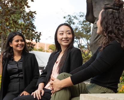 Three female-presenting graduate students on the campus of USC.