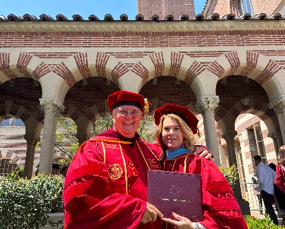 The Taylor family posing in their cap and gown.