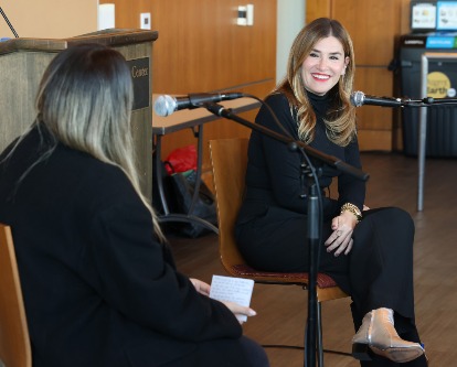 Alli Web smiles by her microphone at a Q&amp;A