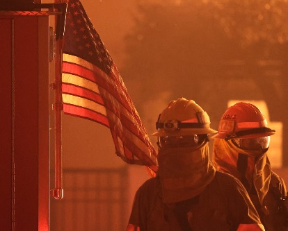 Two firefighters amidst the 2025 Palisades Fire.